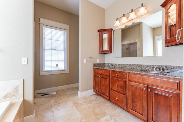 bathroom featuring a sink, baseboards, double vanity, and tiled bath