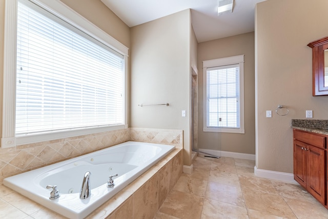 full bath featuring a shower stall, a jetted tub, vanity, and baseboards