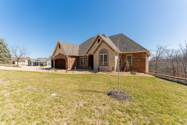 view of front of home featuring a front yard, an attached garage, brick siding, and driveway