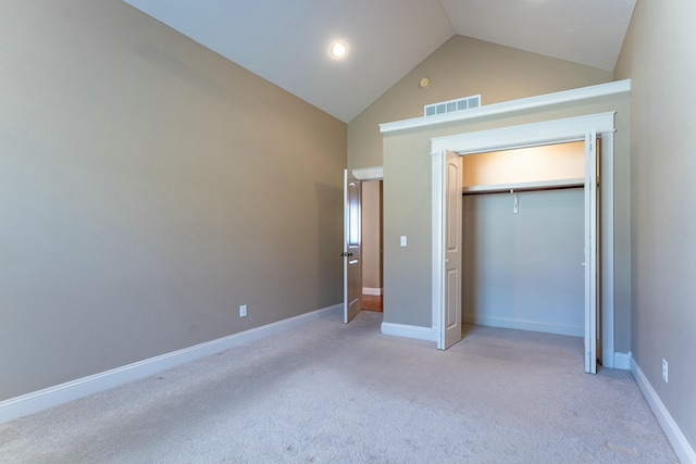 unfurnished bedroom featuring baseboards, visible vents, high vaulted ceiling, a closet, and light carpet