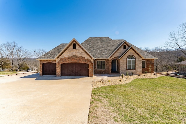 view of front of house featuring driveway, a front lawn, roof with shingles, an attached garage, and brick siding