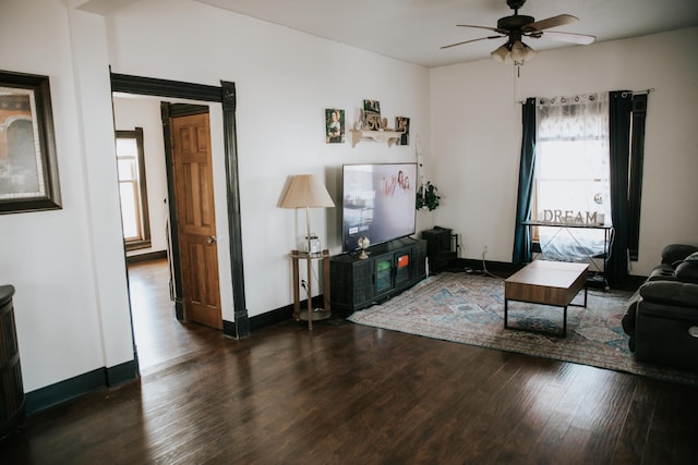 living room with baseboards, wood finished floors, and ceiling fan