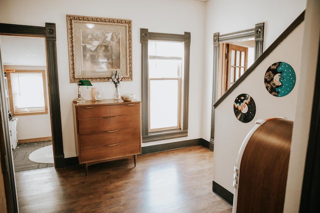 entryway with dark wood-type flooring and baseboards