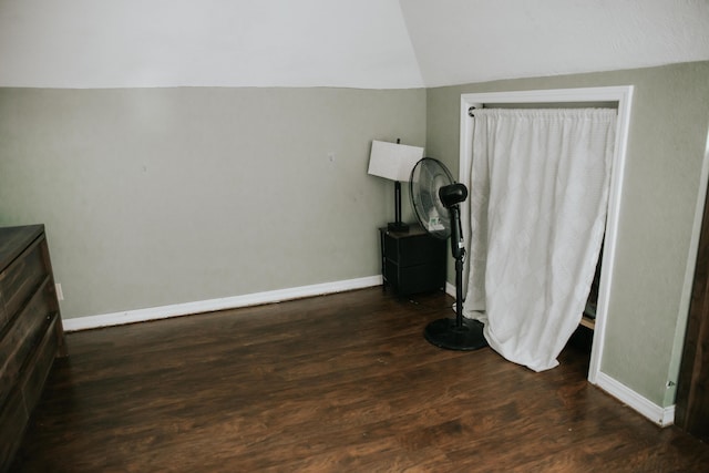 bedroom featuring baseboards, lofted ceiling, and dark wood-style floors