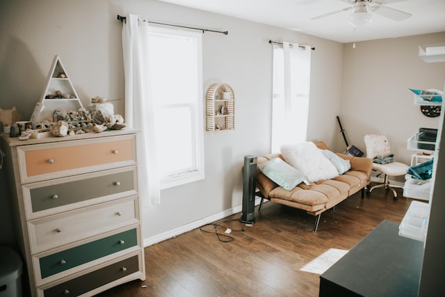 living area with baseboards, dark wood-style flooring, and ceiling fan