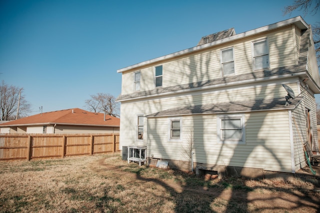 rear view of house with a yard and fence