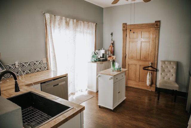 kitchen featuring dark wood-type flooring, a sink, stainless steel dishwasher, white cabinetry, and ceiling fan