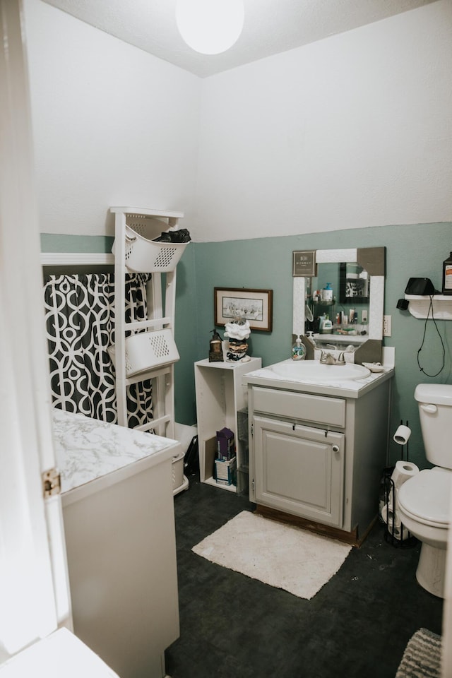 half bath with a sink, toilet, and concrete flooring