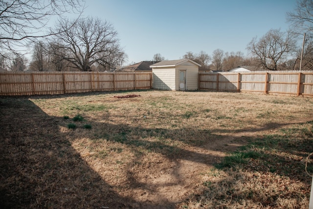 view of yard featuring a storage shed, an outbuilding, and a fenced backyard