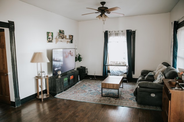 living area with wood finished floors, a ceiling fan, and baseboards