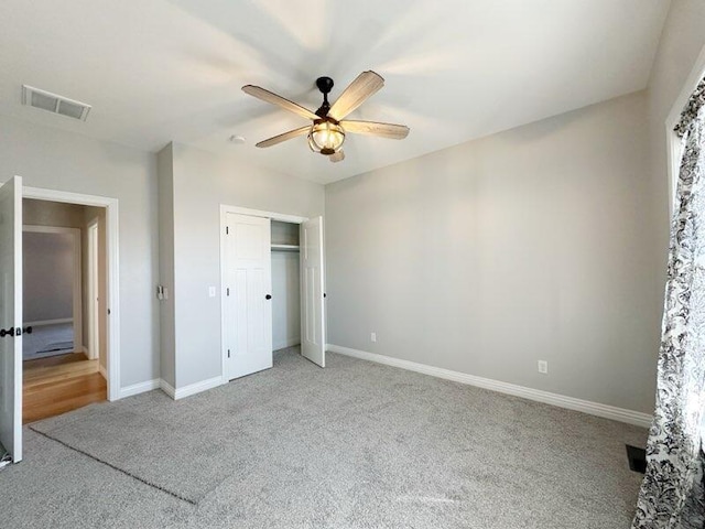 unfurnished bedroom featuring carpet flooring, baseboards, visible vents, and a closet