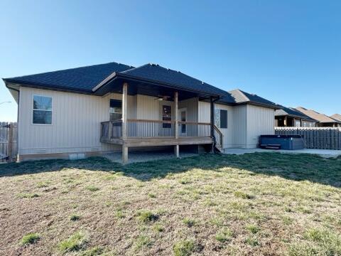 rear view of property featuring crawl space, a wooden deck, a yard, and fence