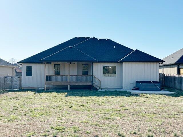 rear view of house featuring a lawn and fence private yard