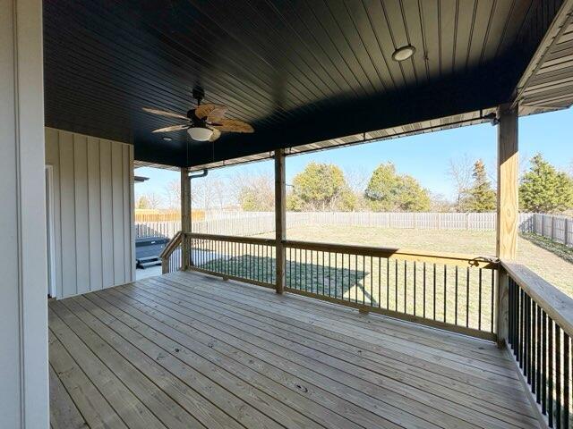 wooden deck with a ceiling fan and a fenced backyard