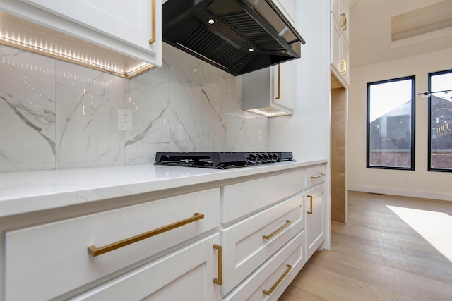 kitchen featuring white cabinetry, custom range hood, and light wood-style floors