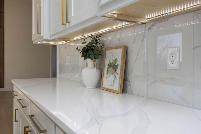 interior space with light stone counters and white cabinetry