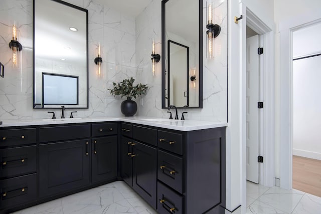 full bathroom with a sink, marble finish floor, and double vanity