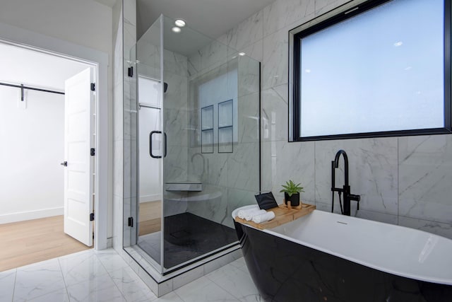 full bath featuring a soaking tub, marble finish floor, and a stall shower