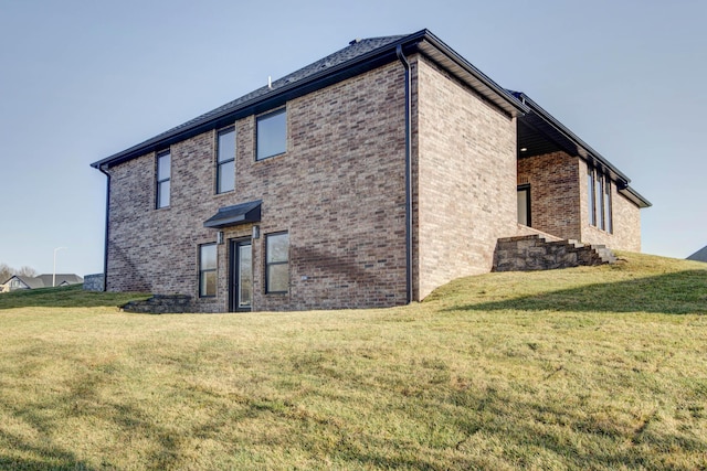 view of side of home with a lawn and brick siding