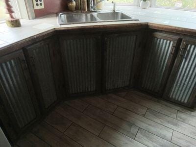 kitchen featuring wood finished floors, light countertops, and a sink