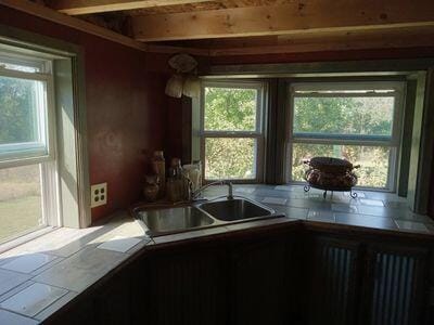 kitchen featuring beam ceiling and a sink