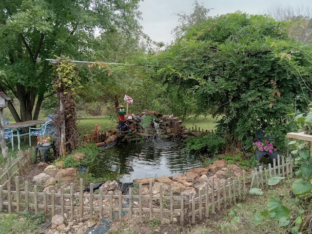 view of yard with a small pond and fence