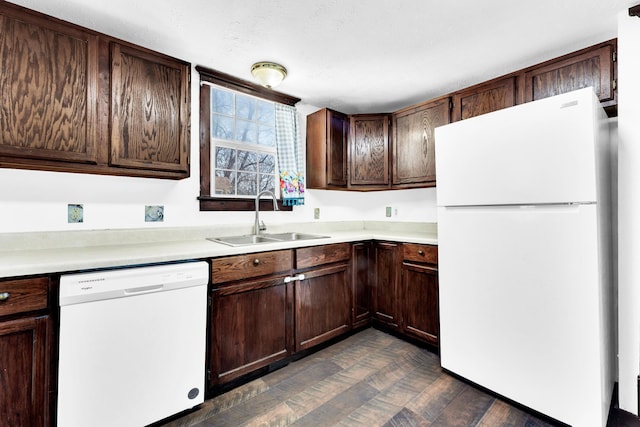 kitchen with a sink, white appliances, dark brown cabinets, and light countertops