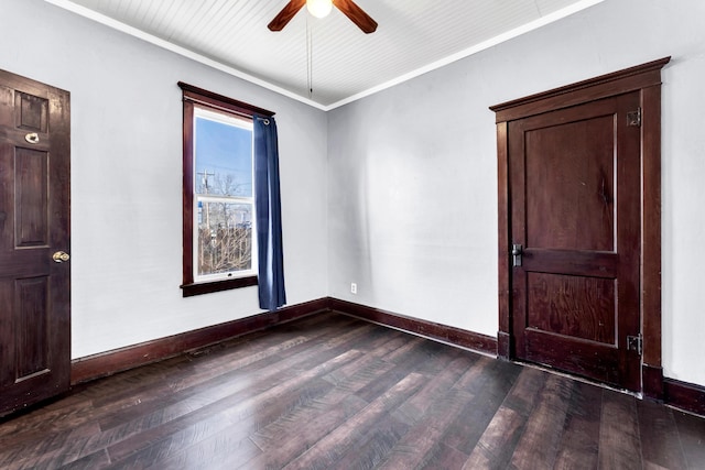 unfurnished room featuring dark wood-type flooring, ornamental molding, baseboards, and ceiling fan