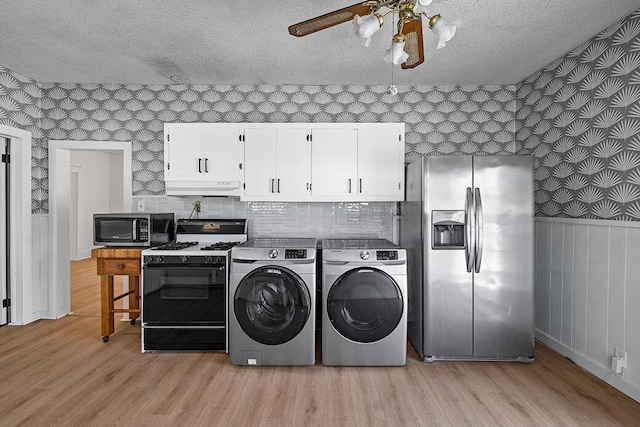 washroom featuring independent washer and dryer, a textured ceiling, wallpapered walls, and a ceiling fan