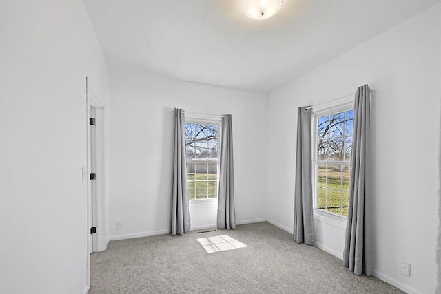 spare room with baseboards and carpet floors