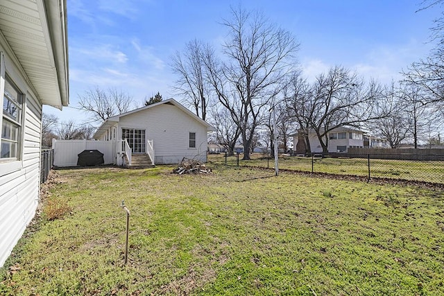 view of yard featuring entry steps and a fenced backyard