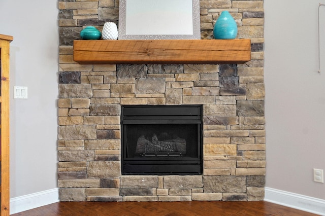 interior details featuring a fireplace, baseboards, and wood finished floors