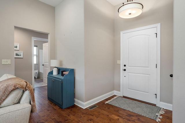 foyer with dark wood-type flooring and baseboards