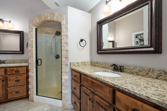 full bathroom featuring tile patterned flooring, a shower stall, two vanities, and a sink