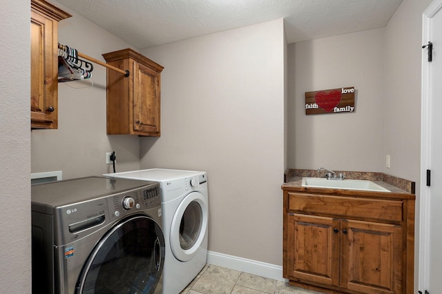 clothes washing area featuring light tile patterned floors, baseboards, cabinet space, a sink, and washing machine and dryer