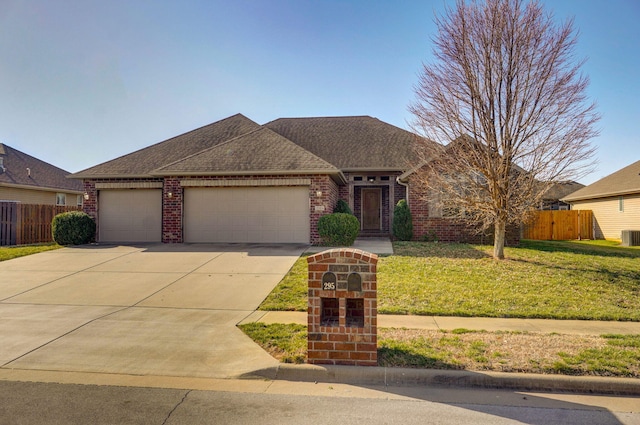 view of front of house with a front yard, fence, an attached garage, concrete driveway, and brick siding