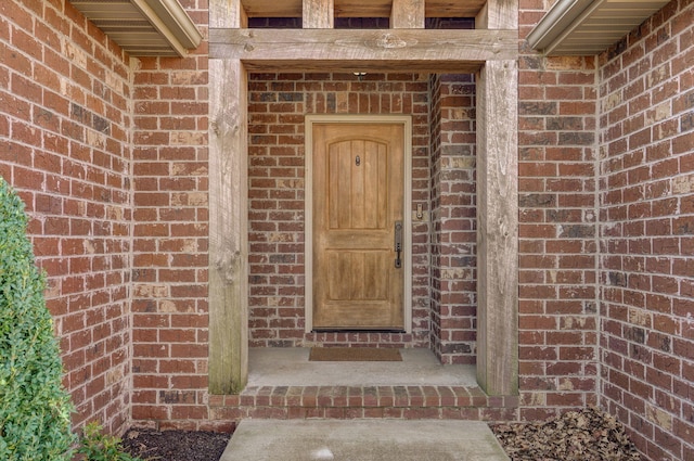 entrance to property featuring brick siding