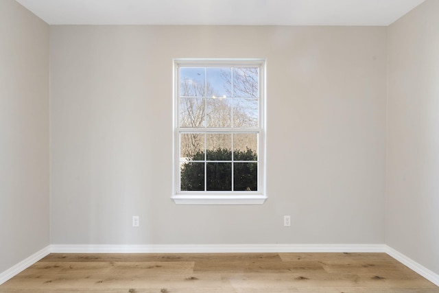 spare room featuring baseboards and wood finished floors