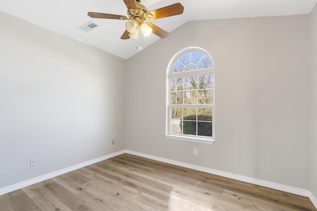 empty room featuring visible vents, baseboards, lofted ceiling, and wood finished floors