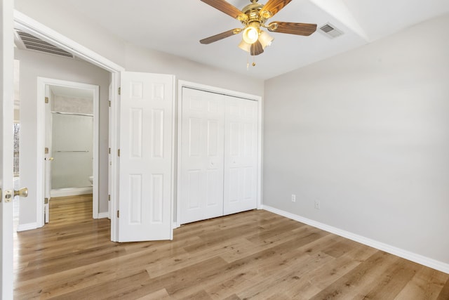 unfurnished bedroom with light wood finished floors, visible vents, a closet, and baseboards