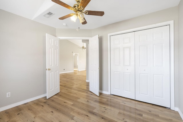 unfurnished bedroom featuring light wood-style flooring, baseboards, visible vents, and a closet