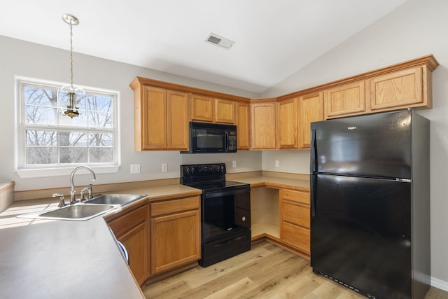 kitchen featuring visible vents, light countertops, lofted ceiling, black appliances, and a sink