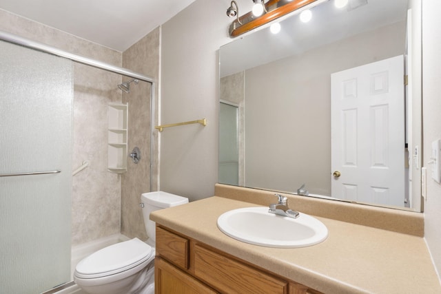 bathroom with vanity, toilet, and a shower with shower door