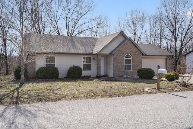 single story home featuring brick siding, a garage, and roof with shingles