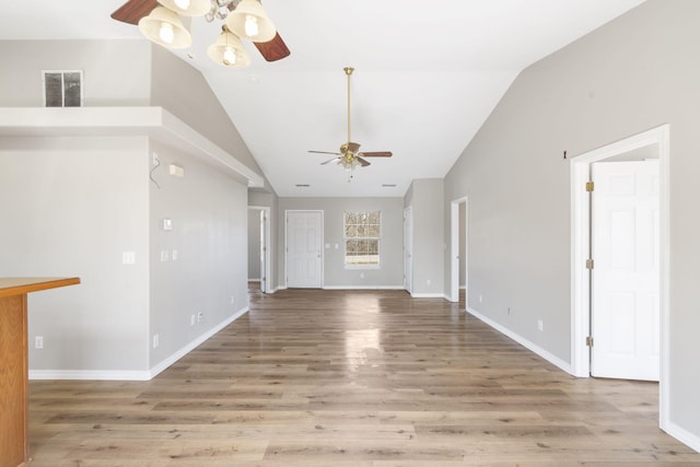 unfurnished living room with wood finished floors, a ceiling fan, visible vents, baseboards, and lofted ceiling