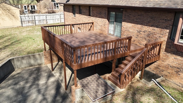 wooden terrace featuring fence and a lawn