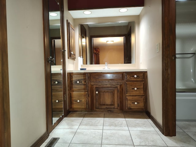 bathroom with vanity, visible vents, baseboards, and tile patterned flooring