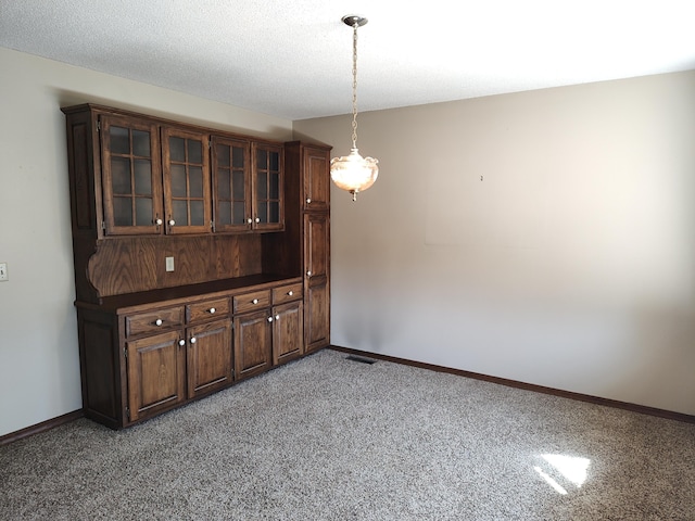 empty room featuring visible vents, light colored carpet, baseboards, and a textured ceiling