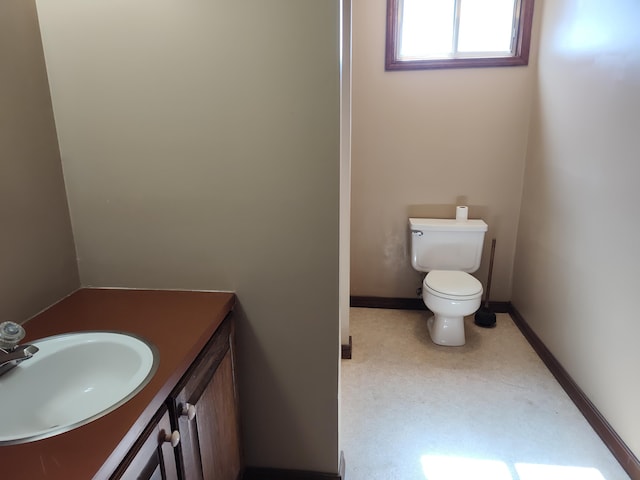 bathroom featuring baseboards, toilet, and vanity