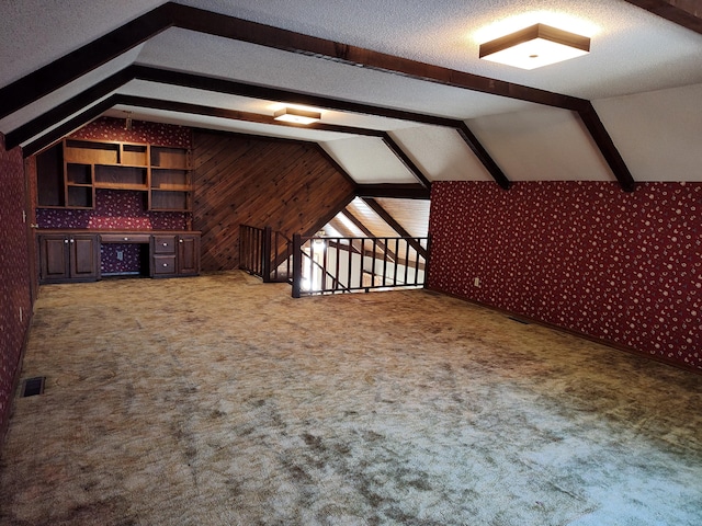 bonus room with visible vents, carpet floors, a textured ceiling, and vaulted ceiling with beams